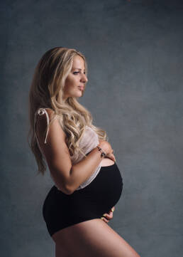 femme enceinte aux cheveux blonds qui porte une culotte de grossesse